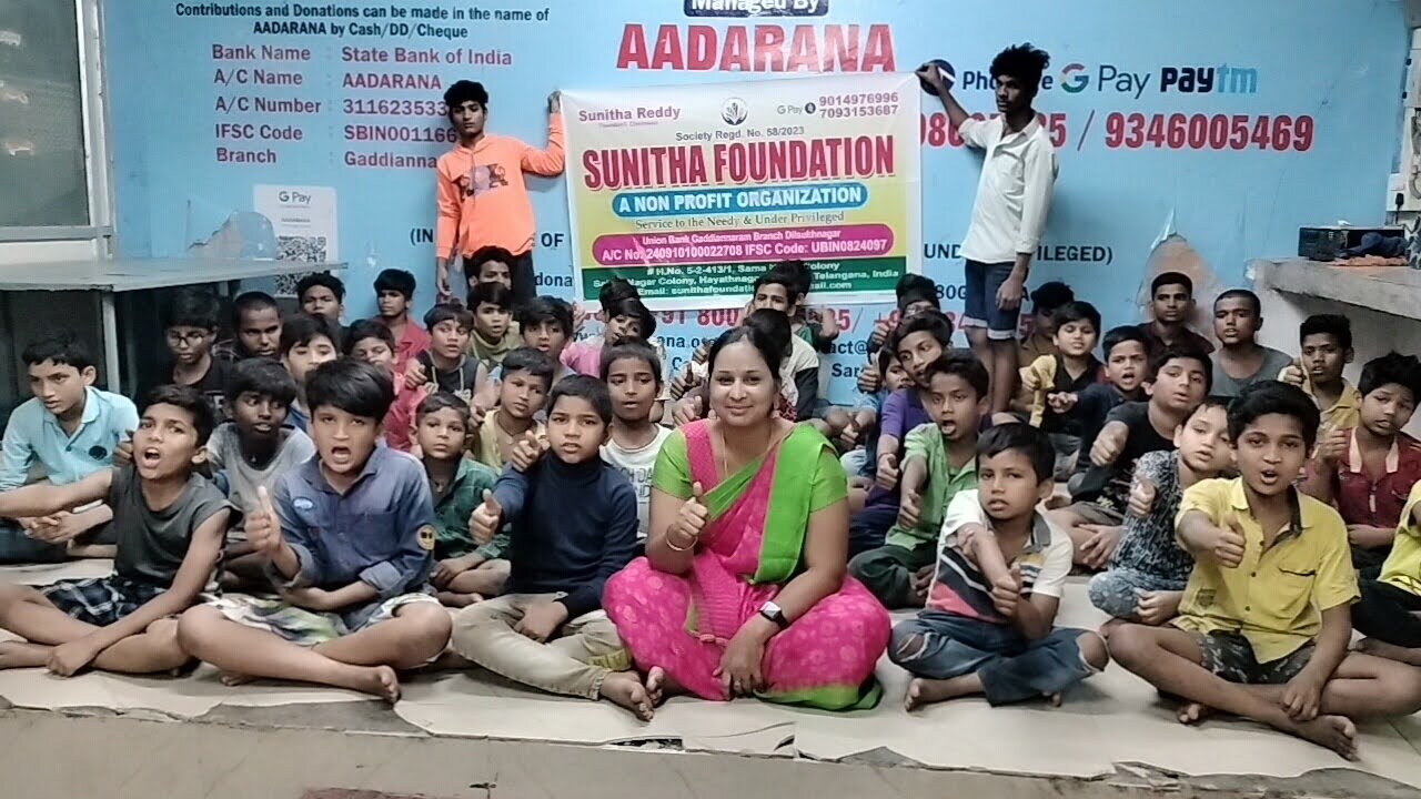 Children seated together in front of a Sunitha Foundation banner