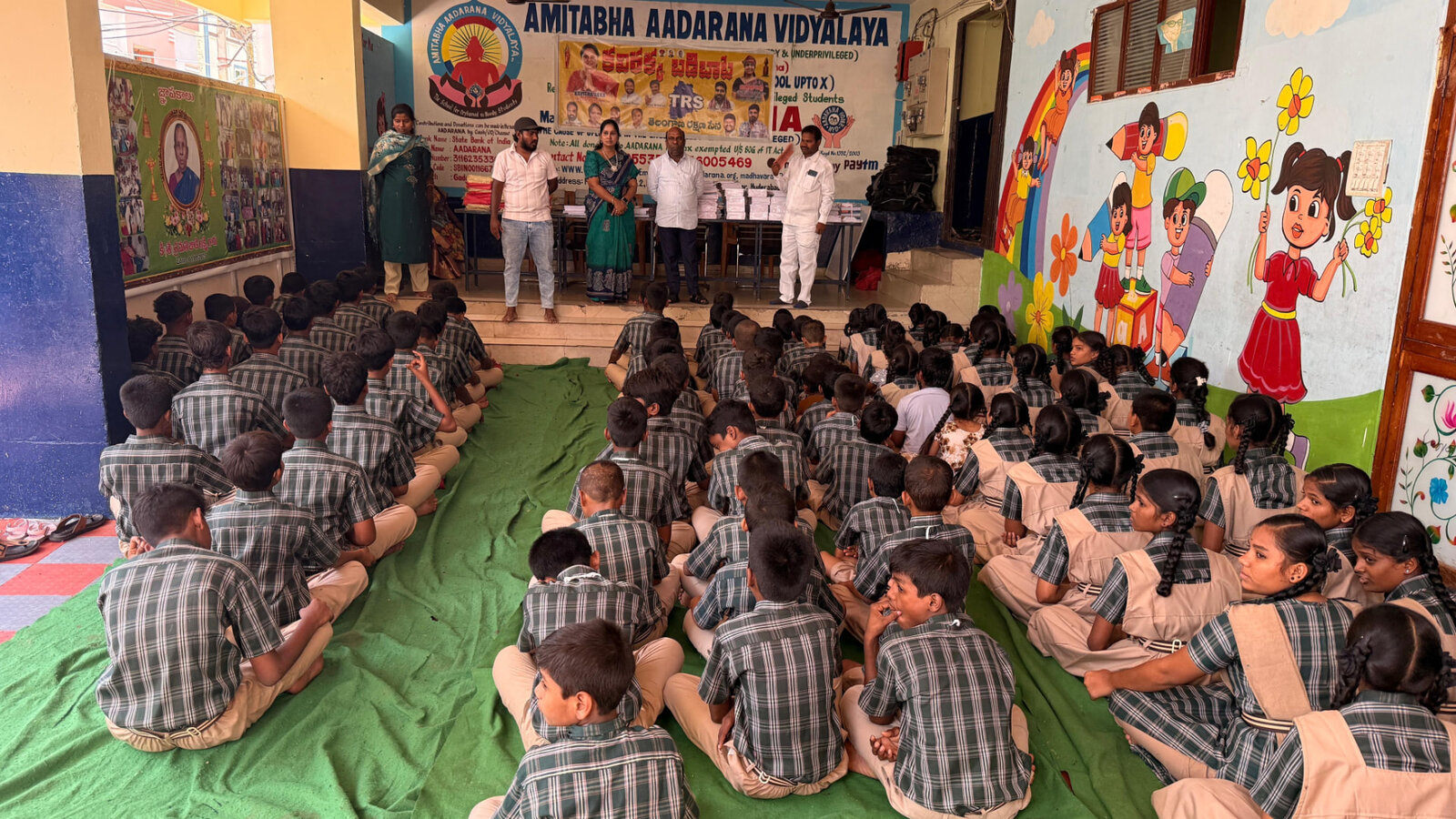 Students seated on the floor during a school assembly